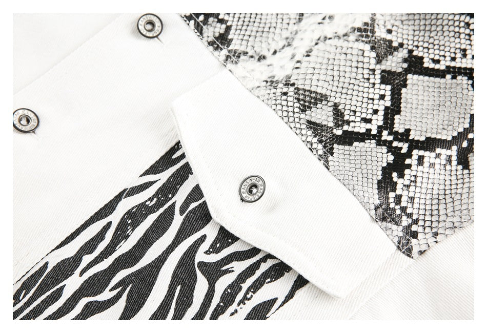 Close-up of white denim with black zebra and snakeskin-pattern panels and round metal snaps.