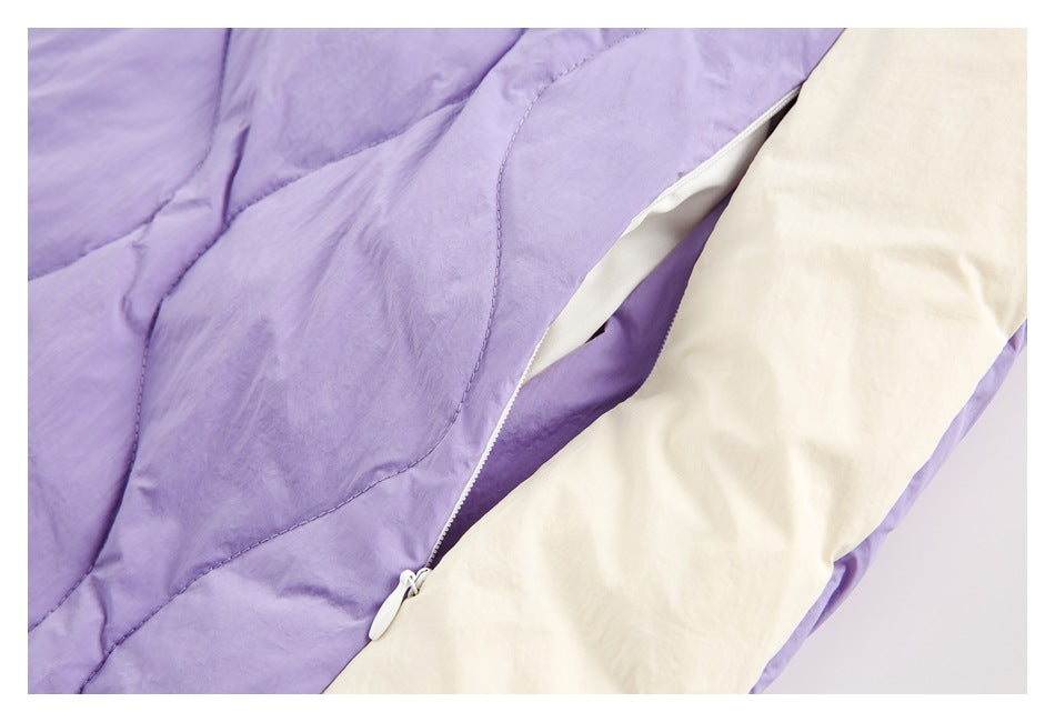 Close-up of a lavender jacket's zipper opening beside a large white fabric panel.