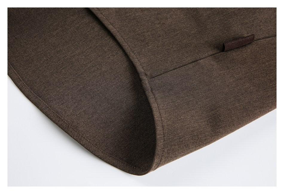 Close-up of a dark brown garment pocket and curved stitched seams.