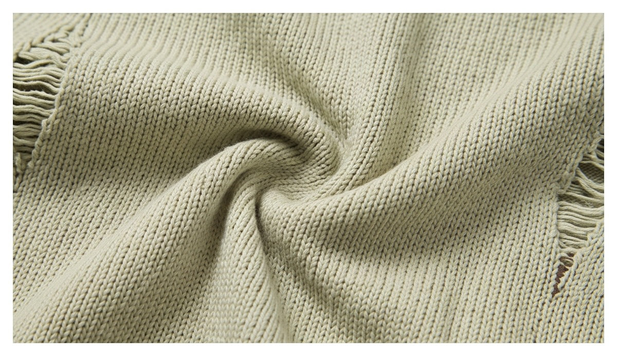 Close-up of cream rib-knit fabric gathered at the center, with fringed edges visible at the sides.
