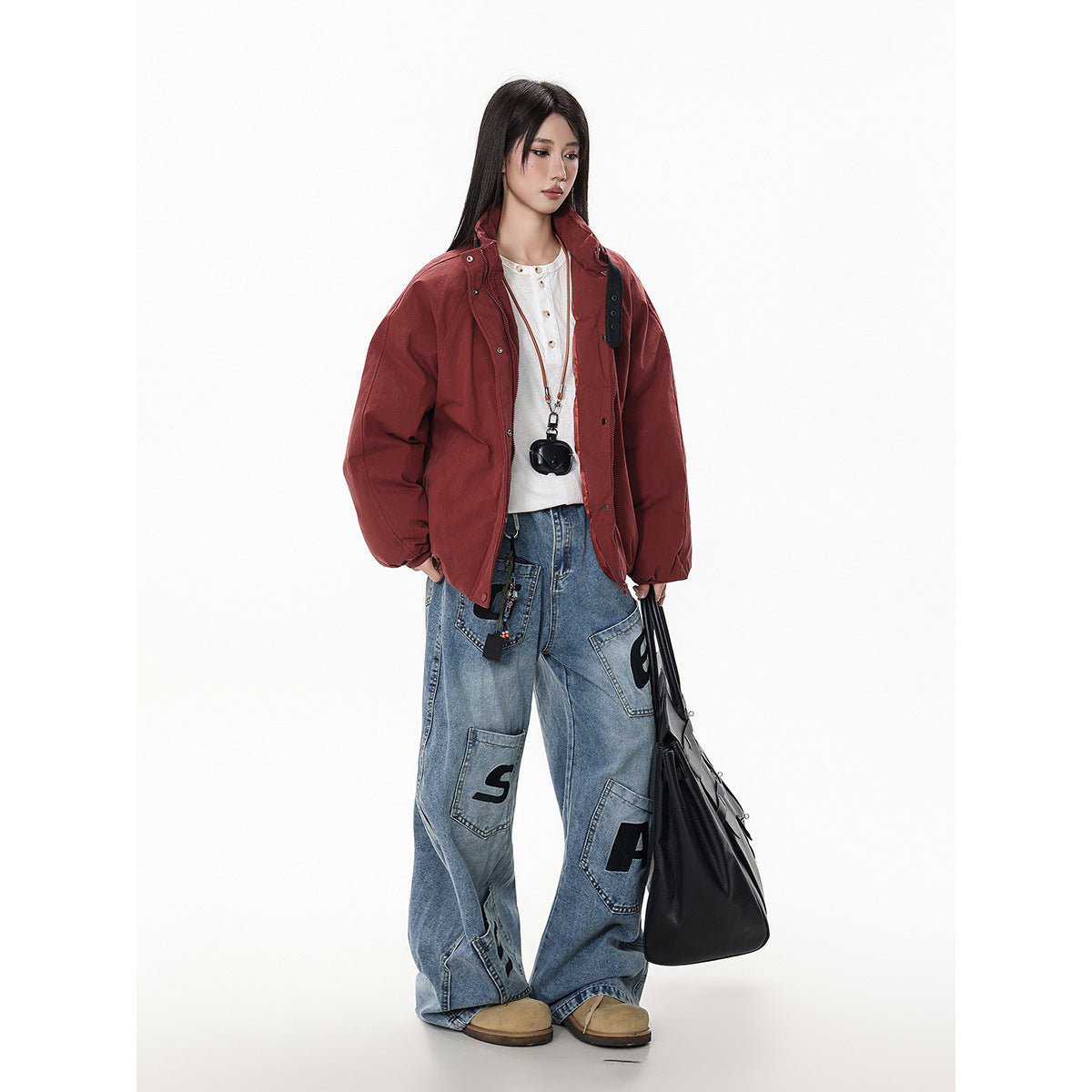 Three-quarter view of a model wearing the rust-red jacket open, showing its snap-and-zip front and high collar.