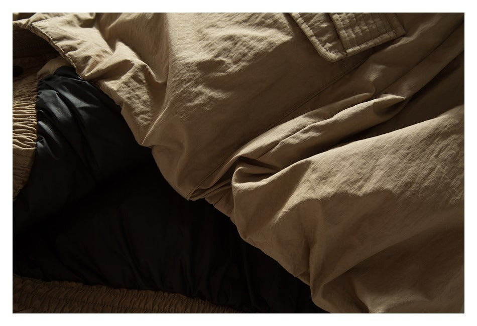 Close-up of the tan jacket fabric draped over its dark lining, with a gathered edge visible.