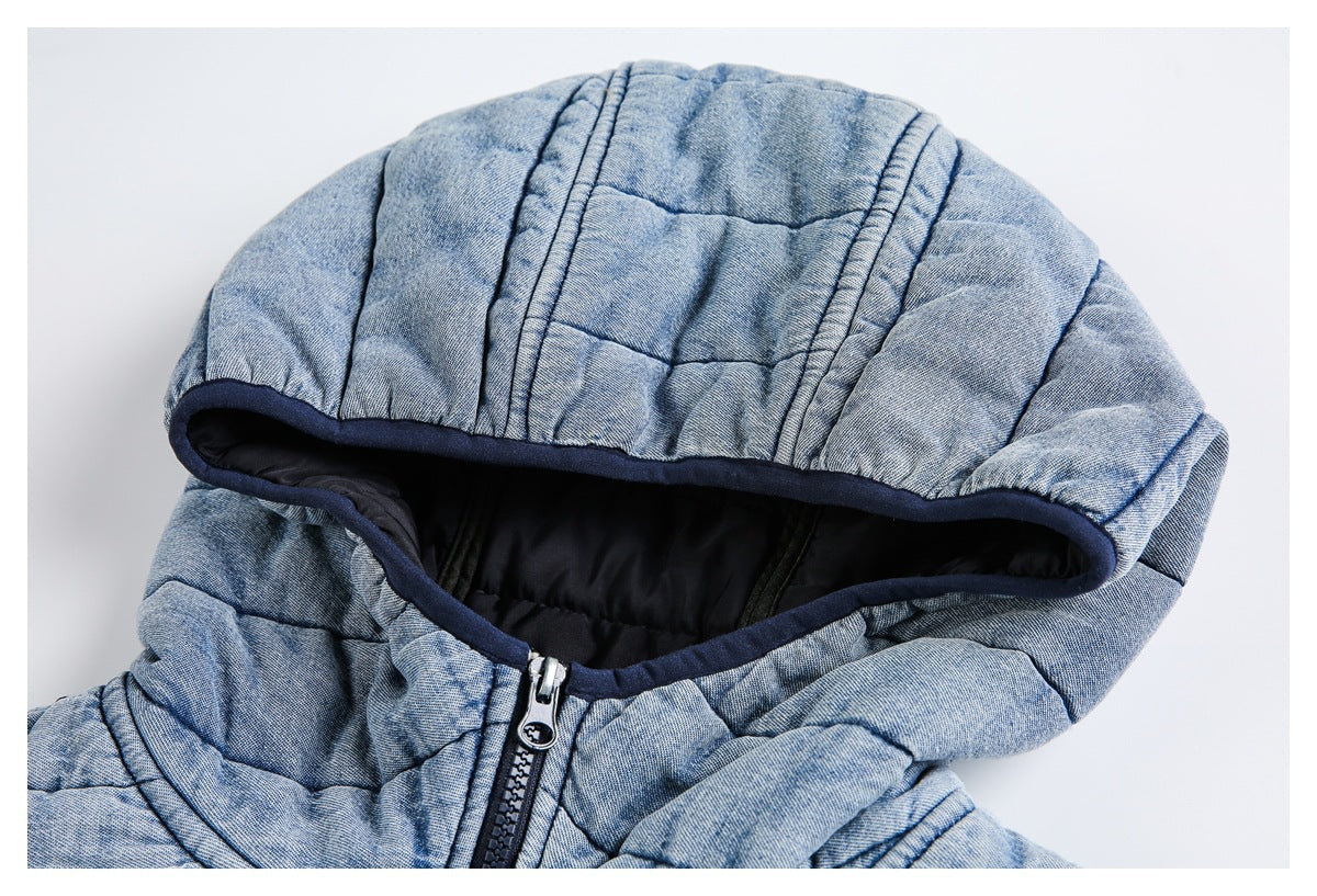 Close-up of a light blue quilted jacket hood with black lining, navy edging, and front zipper.