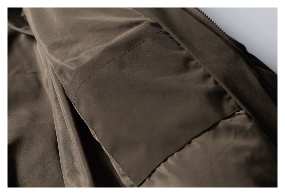 Close-up of the dark brown jacket's interior pocket and lining beside the zipper.