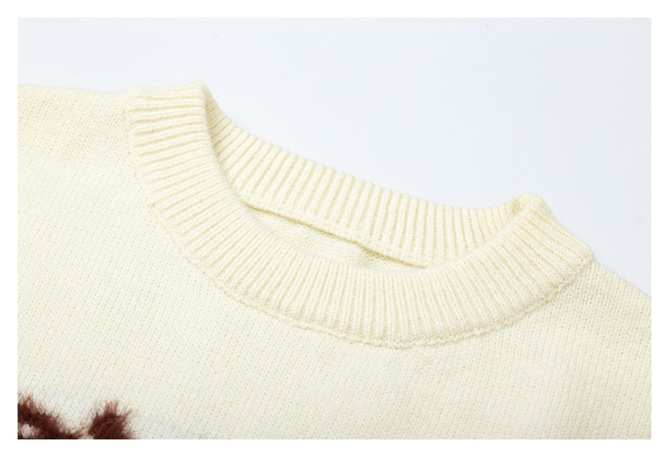 Close-up of the ribbed crew neckline on a cream knit sweater.