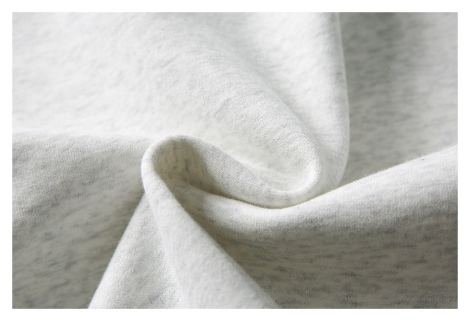 Close-up of softly folded light gray and white knit fabric.