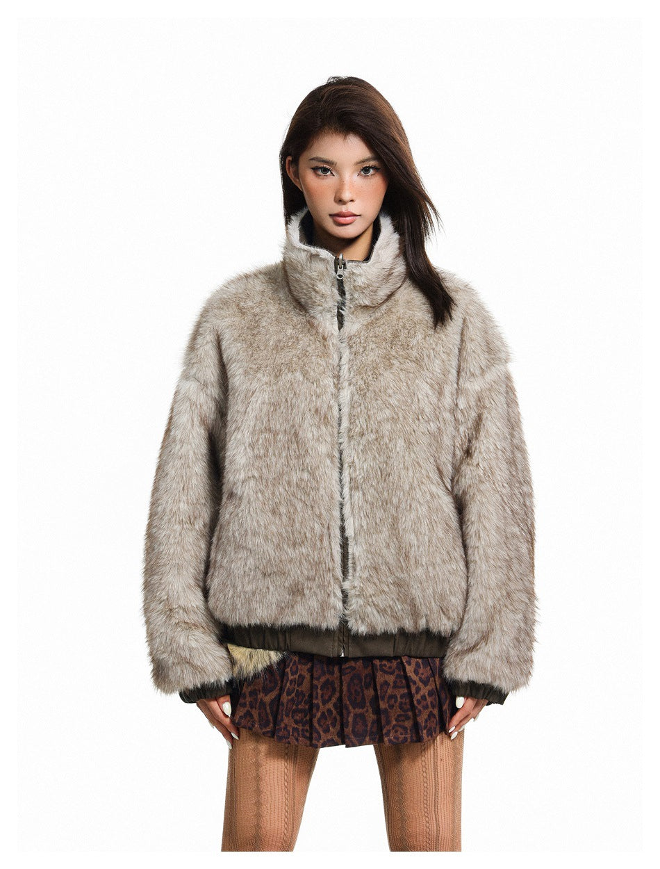 Front view of a model wearing a zipped pale gray-brown fuzzy jacket with a stand collar and dark hem.