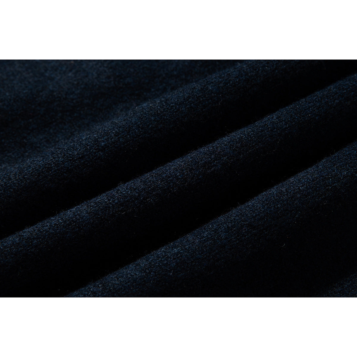 Macro view of dark navy knit fabric folded into soft ridges.