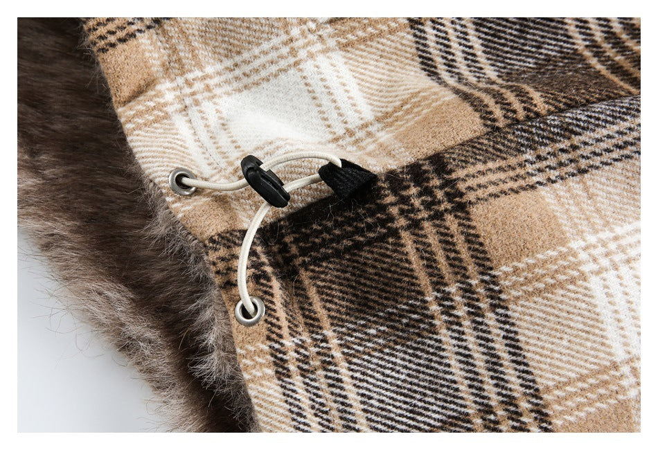 Close-up of a cord, eyelets and toggle on the beige and brown plaid coat beside faux-fur trim.