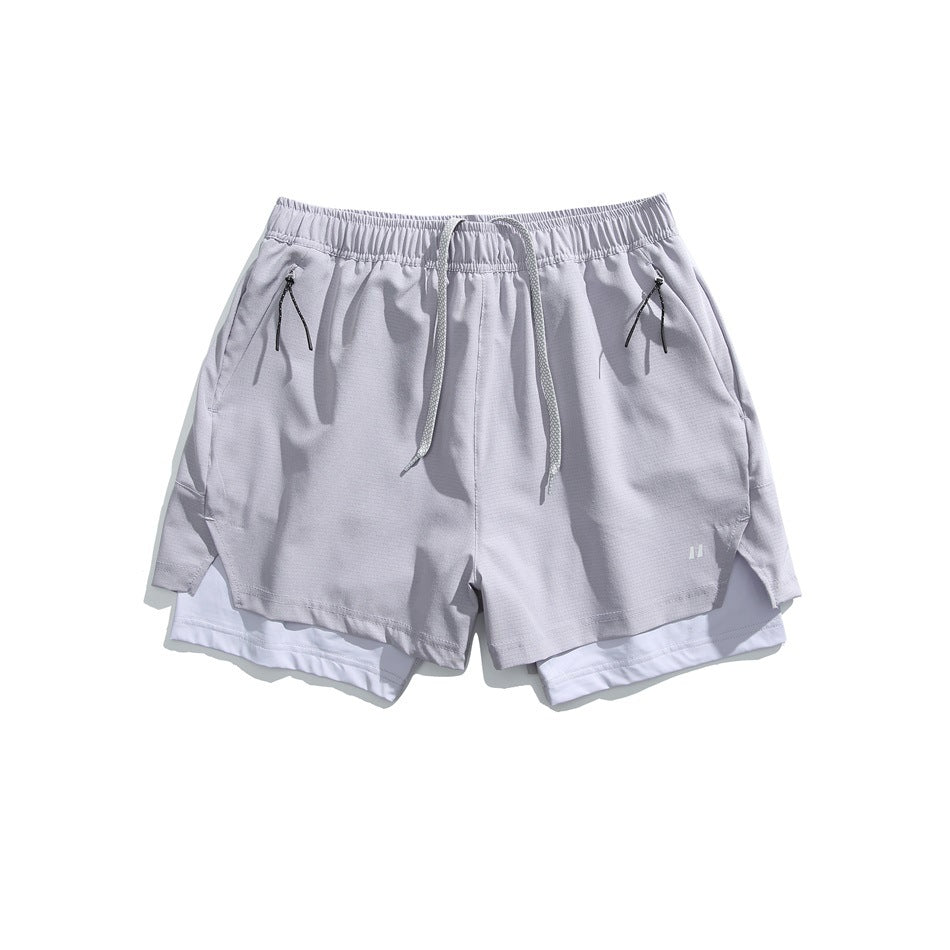 Light gray double-layer athletic shorts with drawcord, zip pockets and white inner layer, flat lay front view