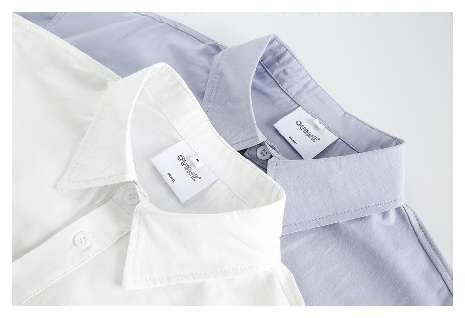 Close-up of white and pale lavender shirts showing their pointed collars, top buttons, and sewn-in labels.