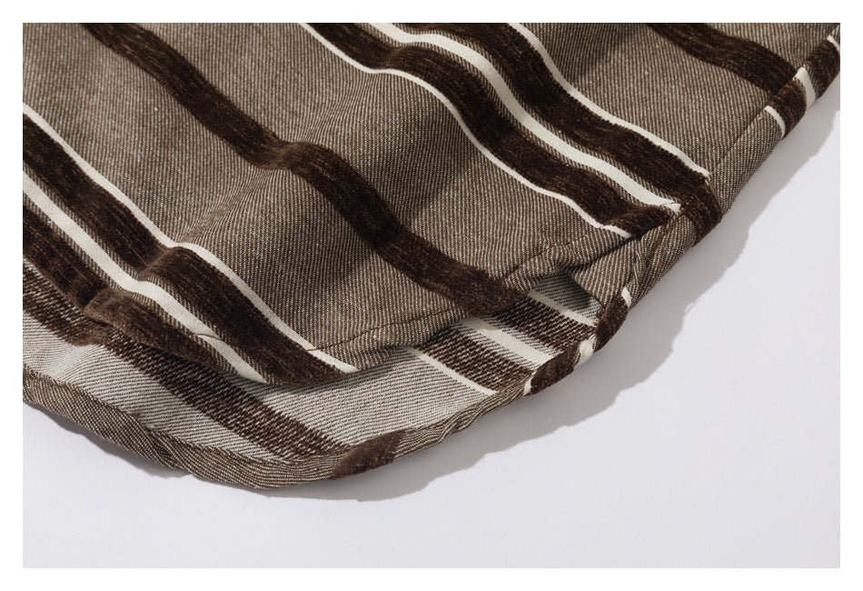 Close-up of the curved hem on taupe fabric with dark brown and cream stripes.
