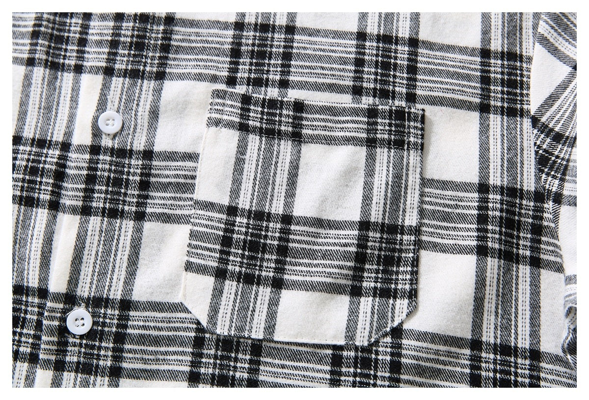 Close-up of a chest pocket on a black-and-white plaid shirt, with white buttons nearby.