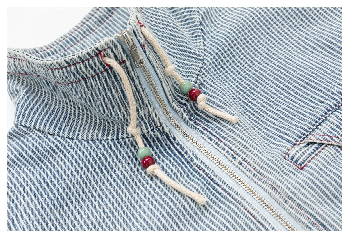 Close-up of the jacket's diagonal blue-and-white stripes, silver zipper and cream drawcords with green and red beads.