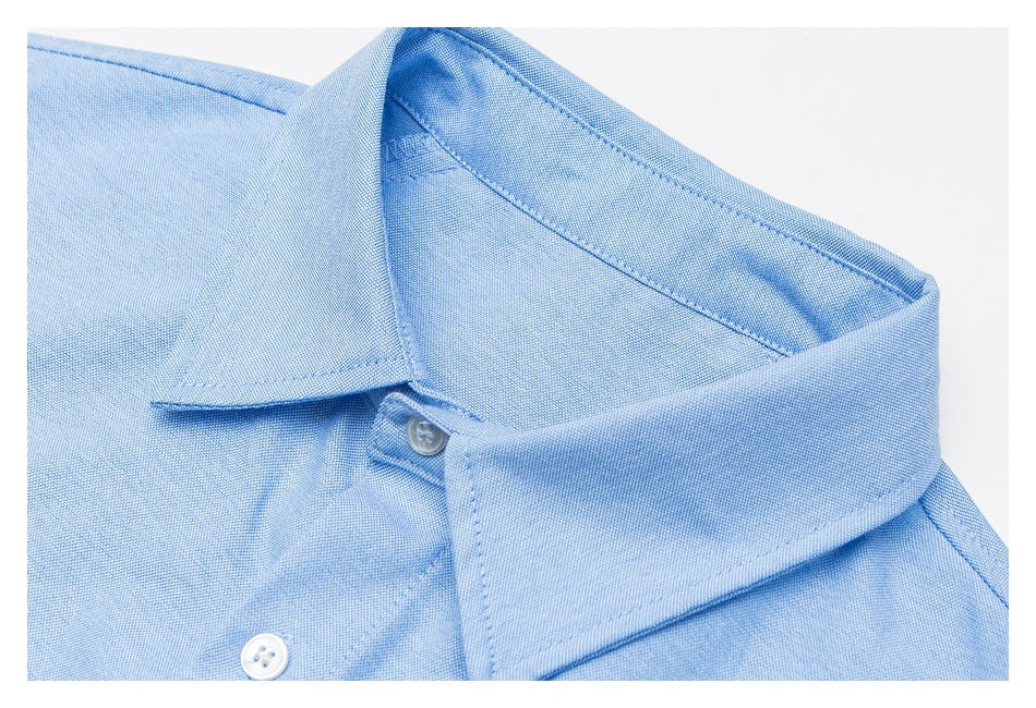 Close-up of a pale blue shirt collar and button placket.