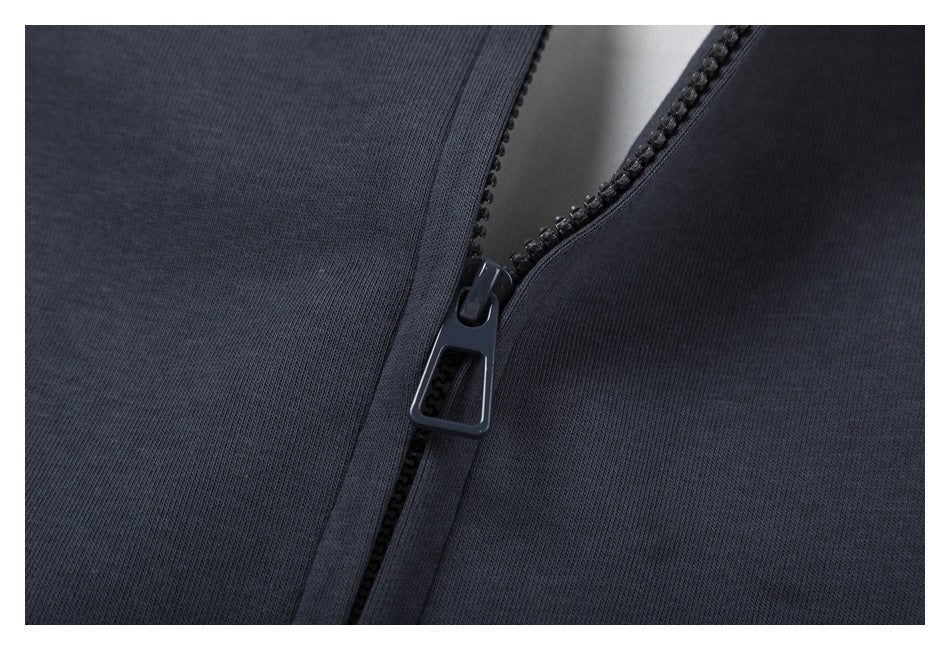 Close-up of the dark zipper and pull on charcoal sweatshirt fabric.