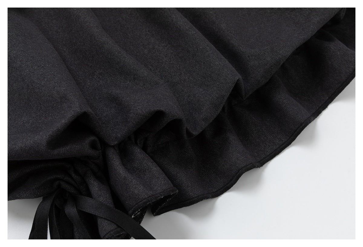 Close-up of the skirt's dark fabric folds and ruffled hem edge.