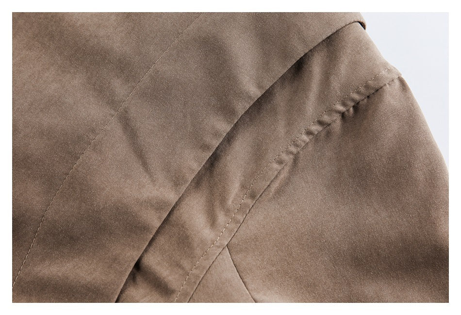 Close-up of stitched seams on the brown jacket's sleeve and body.