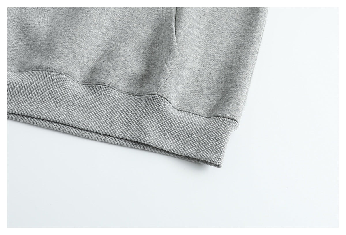 Close-up of the gray sweatshirt's ribbed bottom hem and side seam.