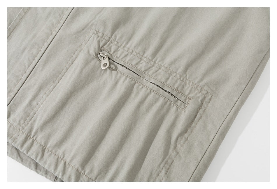 Close-up of a light khaki jacket with a horizontal zip pocket and visible stitching.