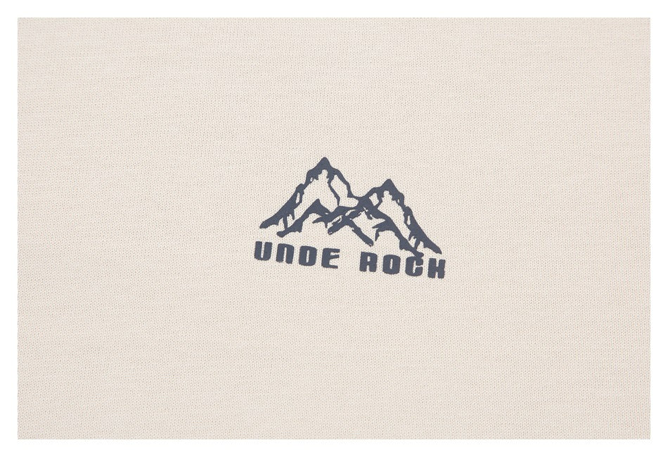 Close-up of a dark mountain graphic and UNDER ROCK lettering printed on off-white fabric.