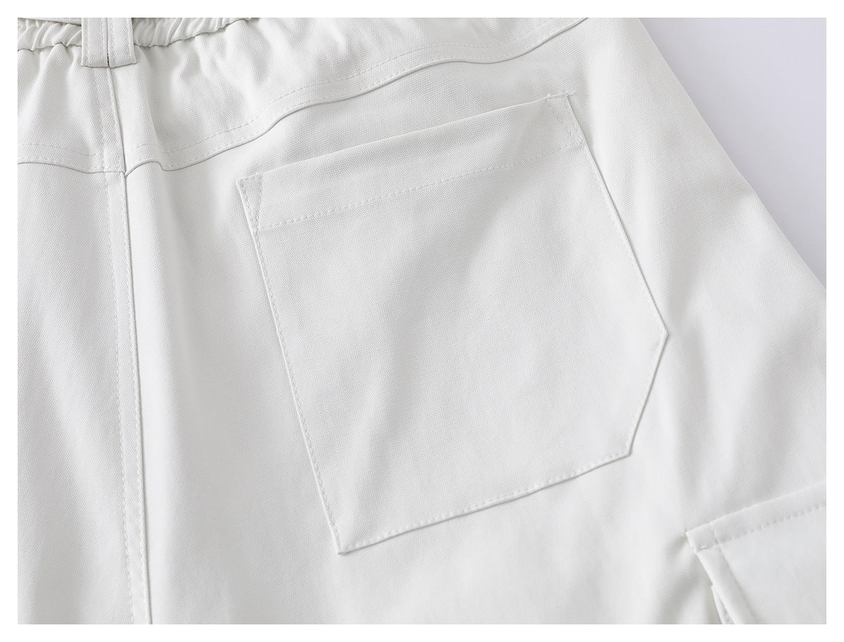 Close-up of a large angular rear patch pocket on the white shorts.