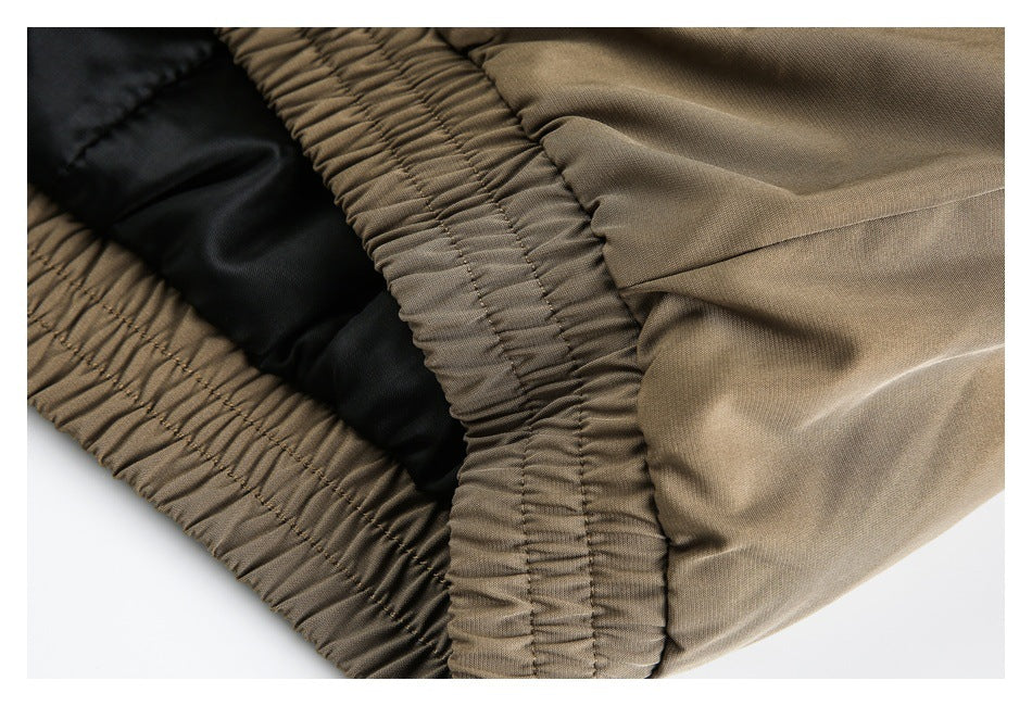 Close-up of the gathered elastic waistband and black inner lining of tan trousers.