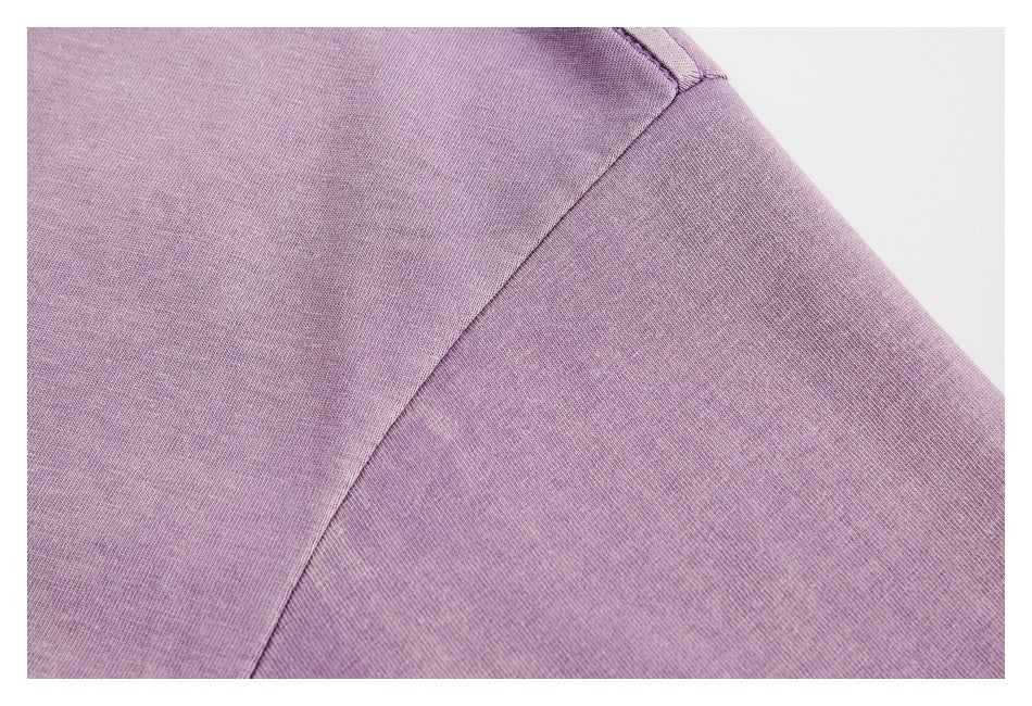 Close-up of a lavender garment's shoulder and sleeve seam.