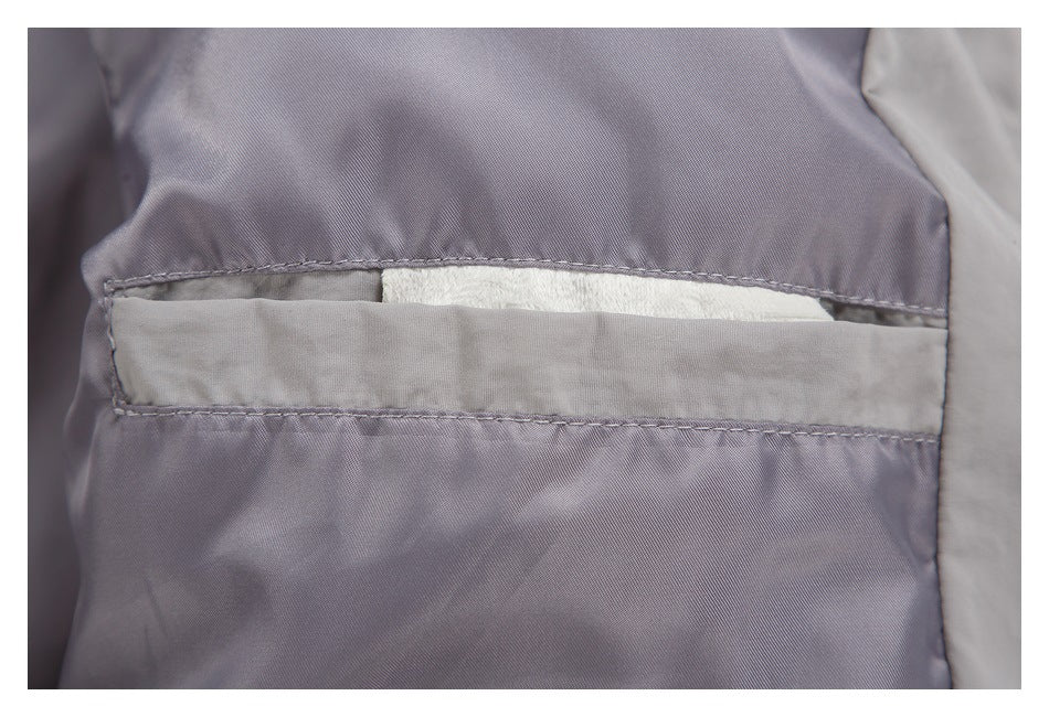 Close-up of a gray-lavender garment with a stitched horizontal pocket and white fabric visible inside.