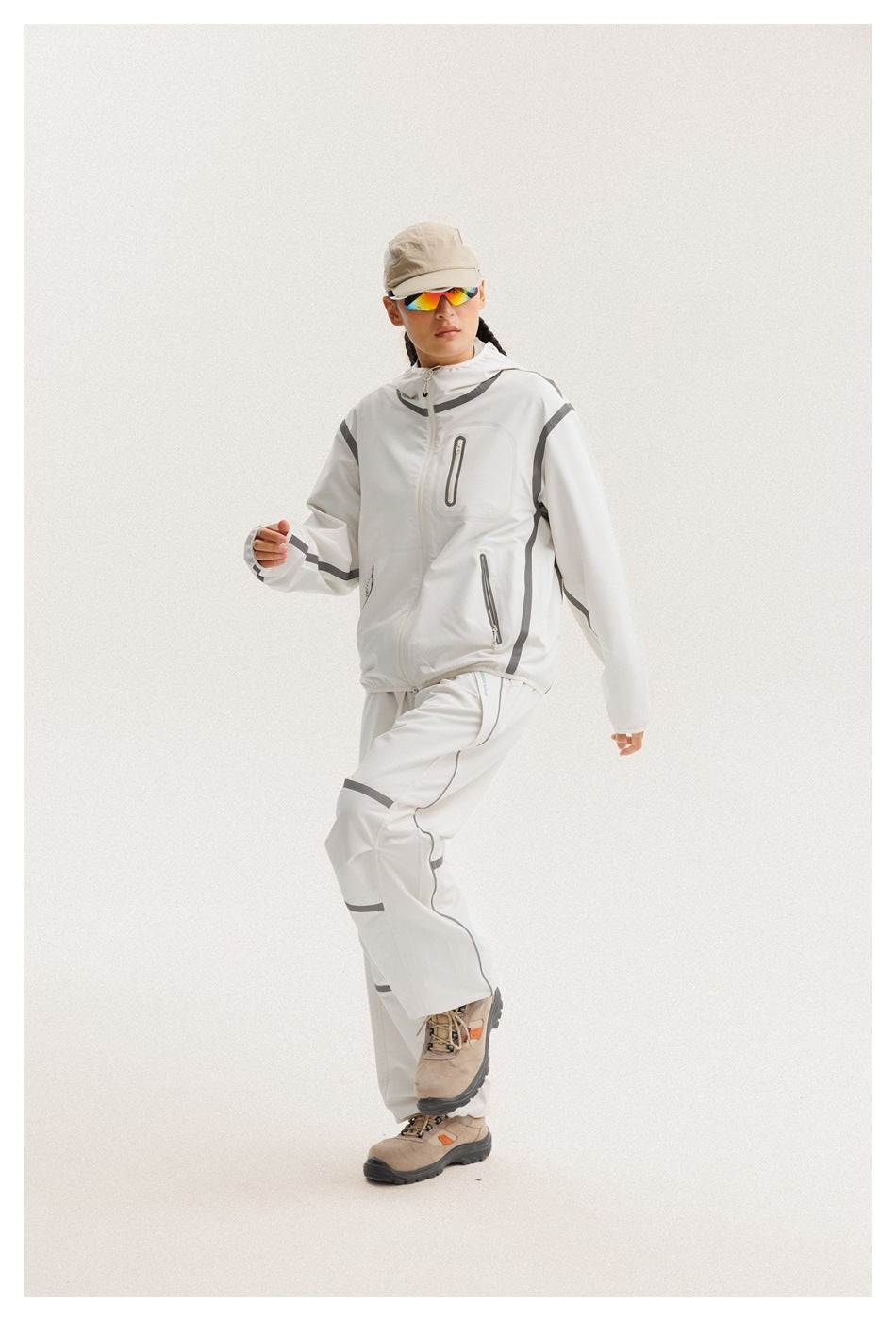 Model wears a white hooded zip jacket with gray accents and matching loose pants.