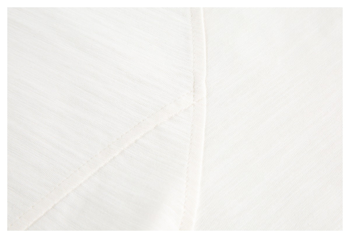 Close-up of off-white knit fabric with a diagonal stitched seam.