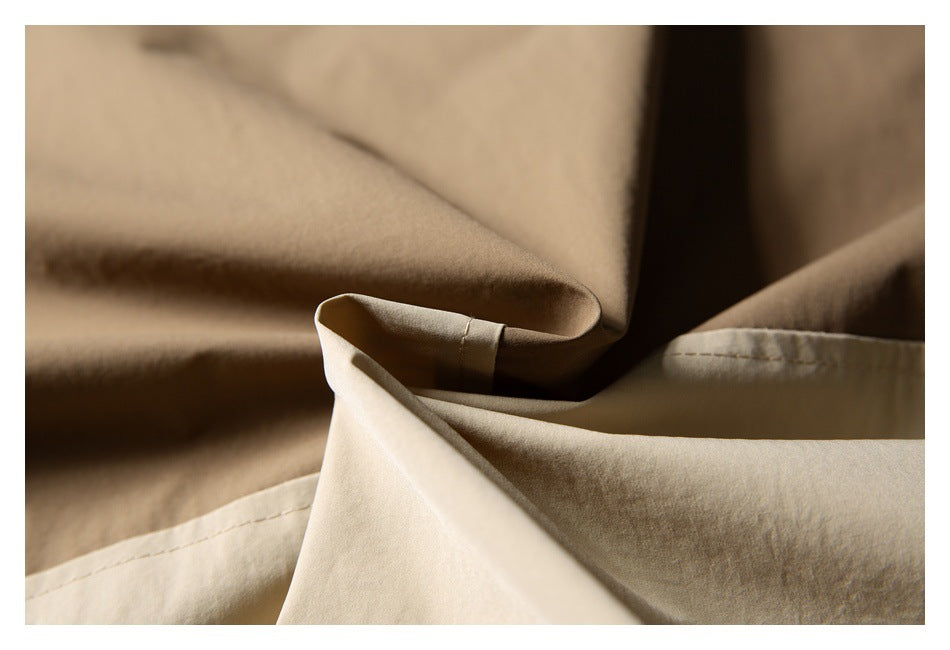 Close-up of folded beige fabric with visible stitched seams.