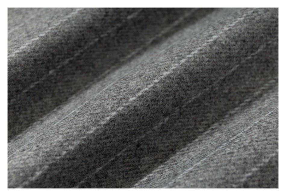 Macro view of heathered gray garment fabric showing its fuzzy surface and subtle diagonal texture.