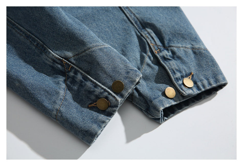 Close-up of blue denim jacket cuffs with brass-tone snap buttons.