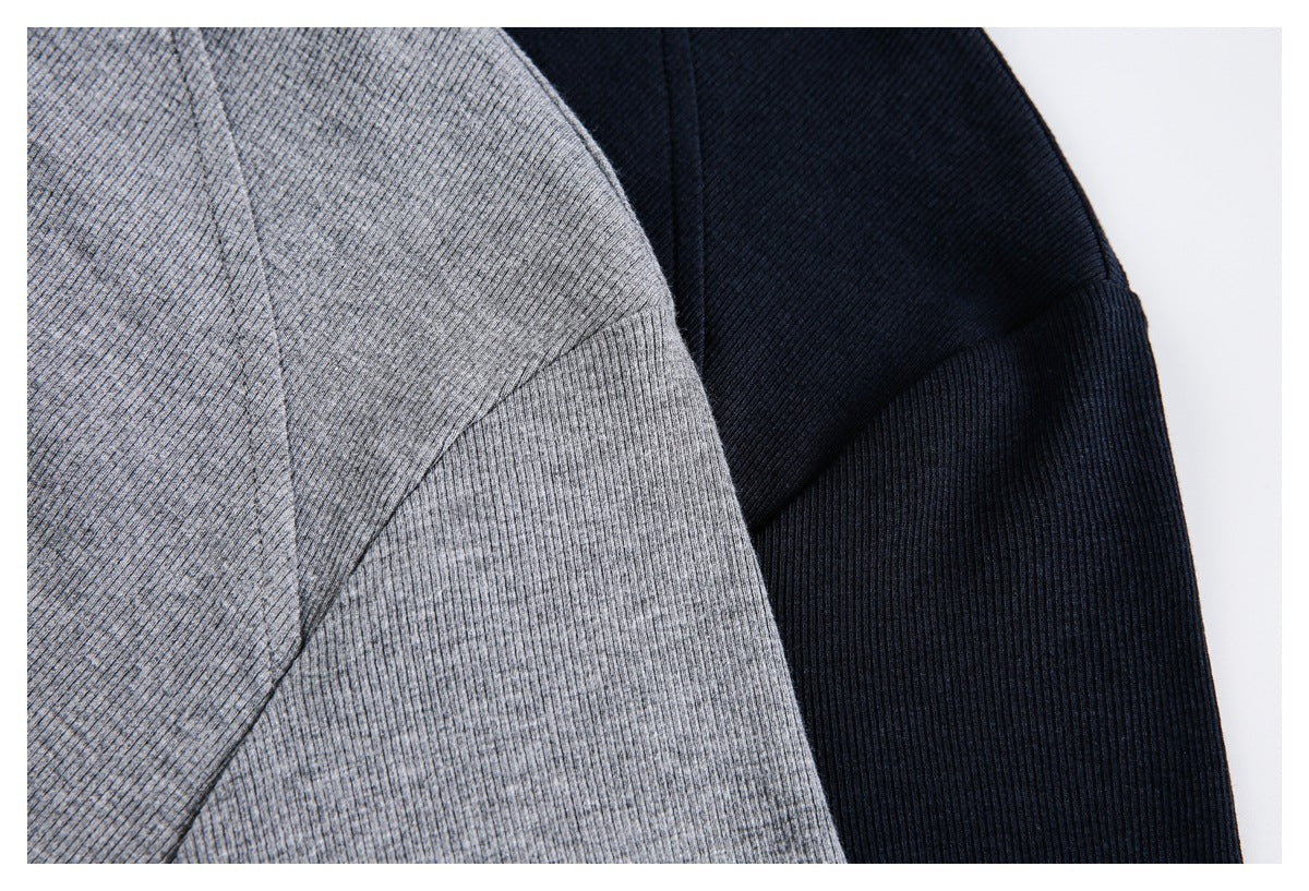 Close-up of gray and dark navy ribbed fabric and stitching on two shirts.