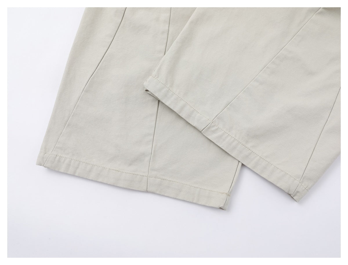 Close-up of the stitched hems and seams on the light ivory wide-leg trousers.