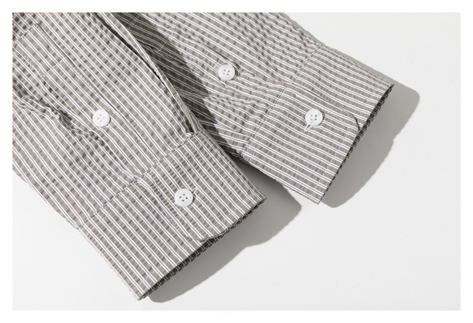 Close-up of two buttoned cuffs on a taupe-and-white striped shirt.