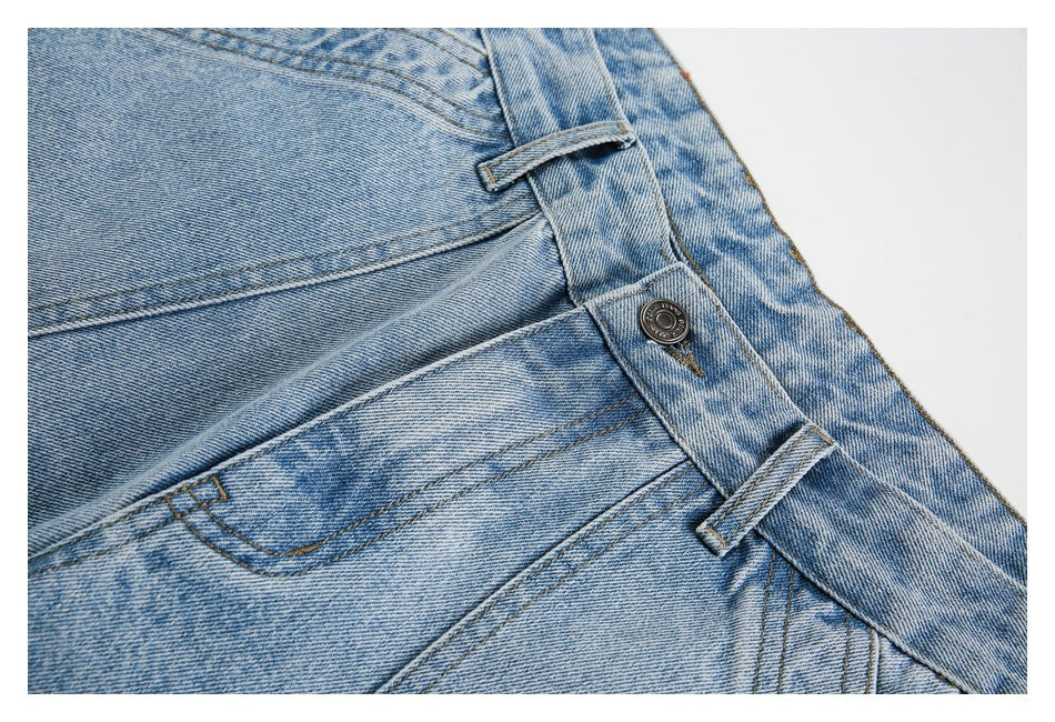 Close-up of the denim shorts' metal waist button, belt loops and front pocket stitching.