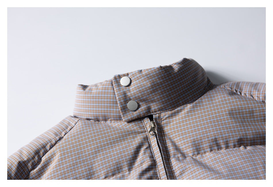 Close-up of a blue-gray and tan checked padded jacket collar, snap buttons, and front zipper.