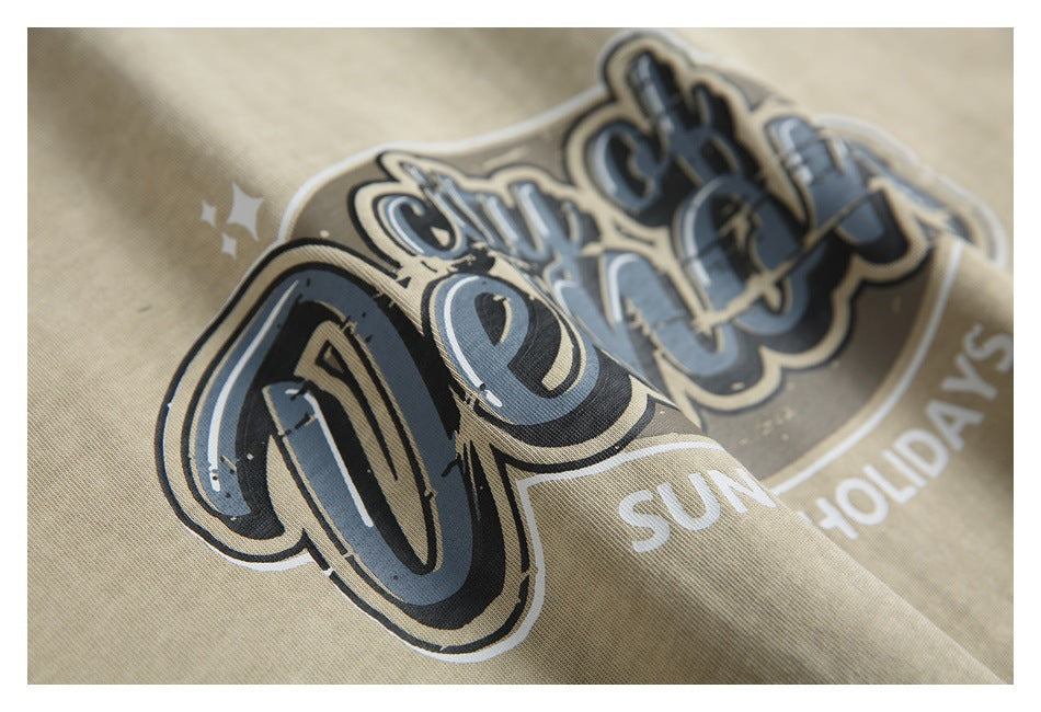 Angled close-up of the raised-looking black, gray, and white chest graphic on beige fabric.