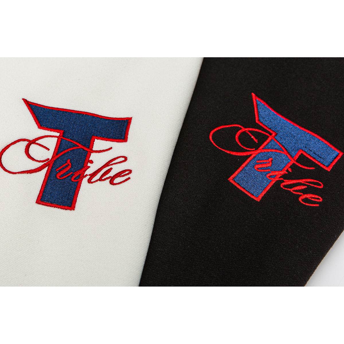 Close-up of matching red-and-blue embroidered script on ivory and black jacket fabric.