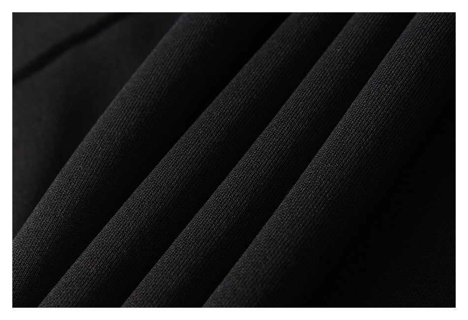 Close-up of black fabric draped in folds, showing its fine textured surface.