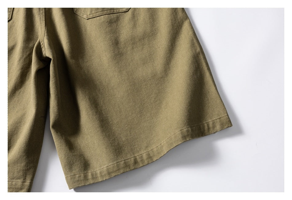 Close-up of an olive-khaki shorts leg and its stitched hem.