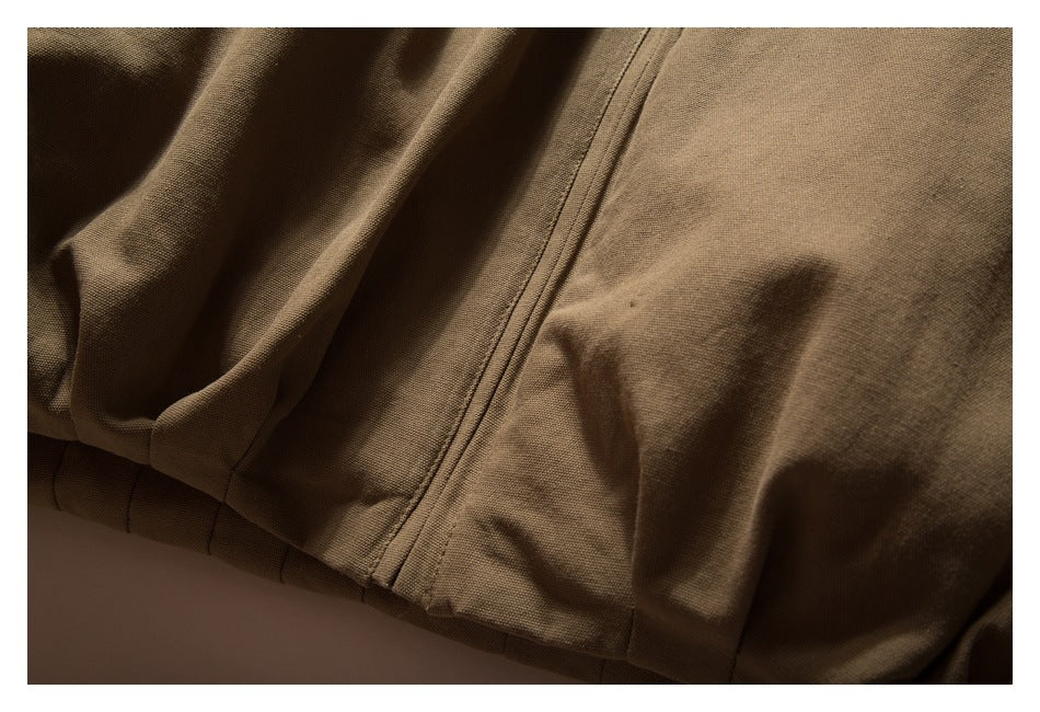 Close-up of the brown jacket's front zipper seam and lower hem stitching.