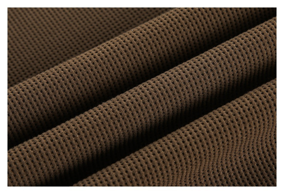 Close-up of brown fabric with a raised, evenly spaced perforated texture.