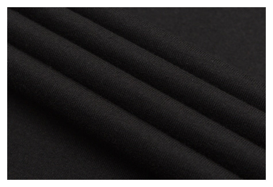 Close-up of black fabric draped in soft folds, showing its fine knit texture.