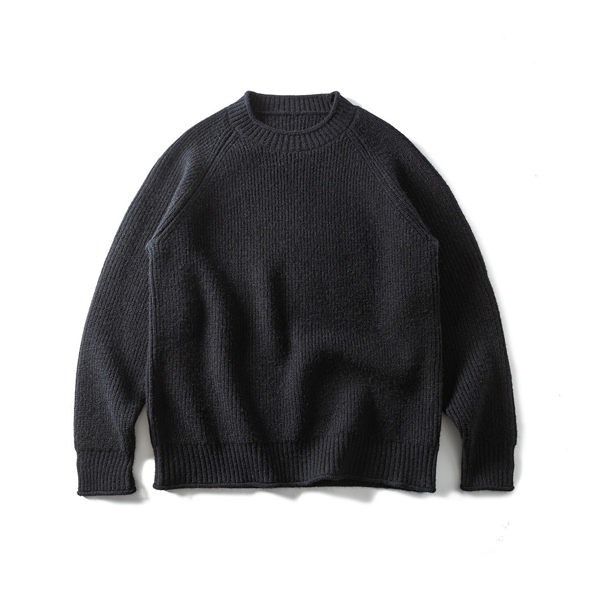 Black ribbed knit crew-neck raglan sweater laid flat, front view