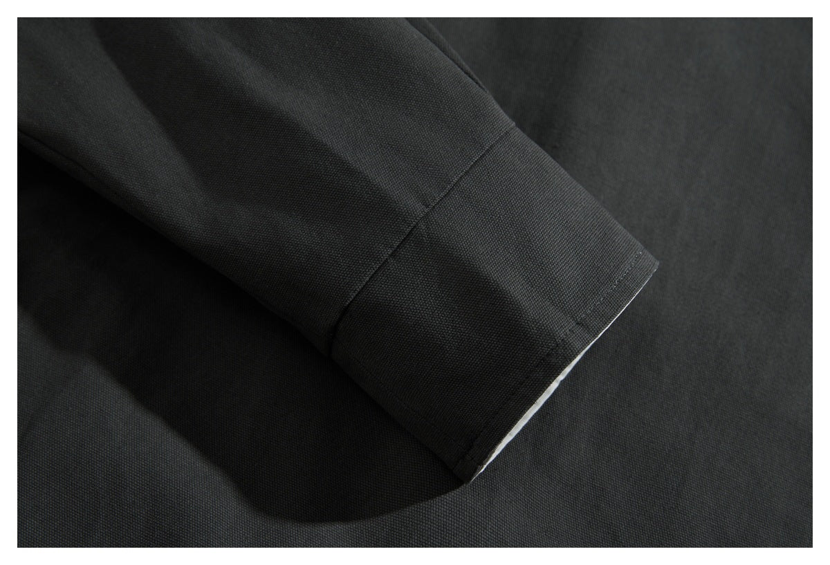 Close-up of a charcoal sleeve cuff with visible stitching and a narrow light inner edge.