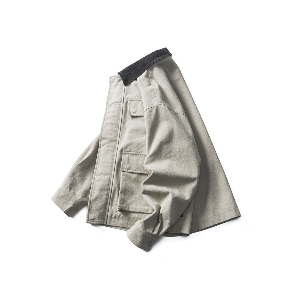 Angled side view of a pale gray-green jacket showing its dark collar, front placket and flap pockets.