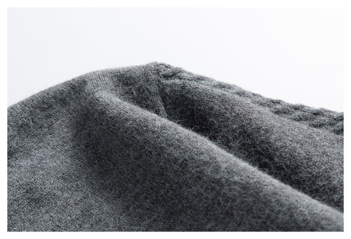 Close-up of charcoal gray fuzzy knit fabric arranged in soft raised folds.